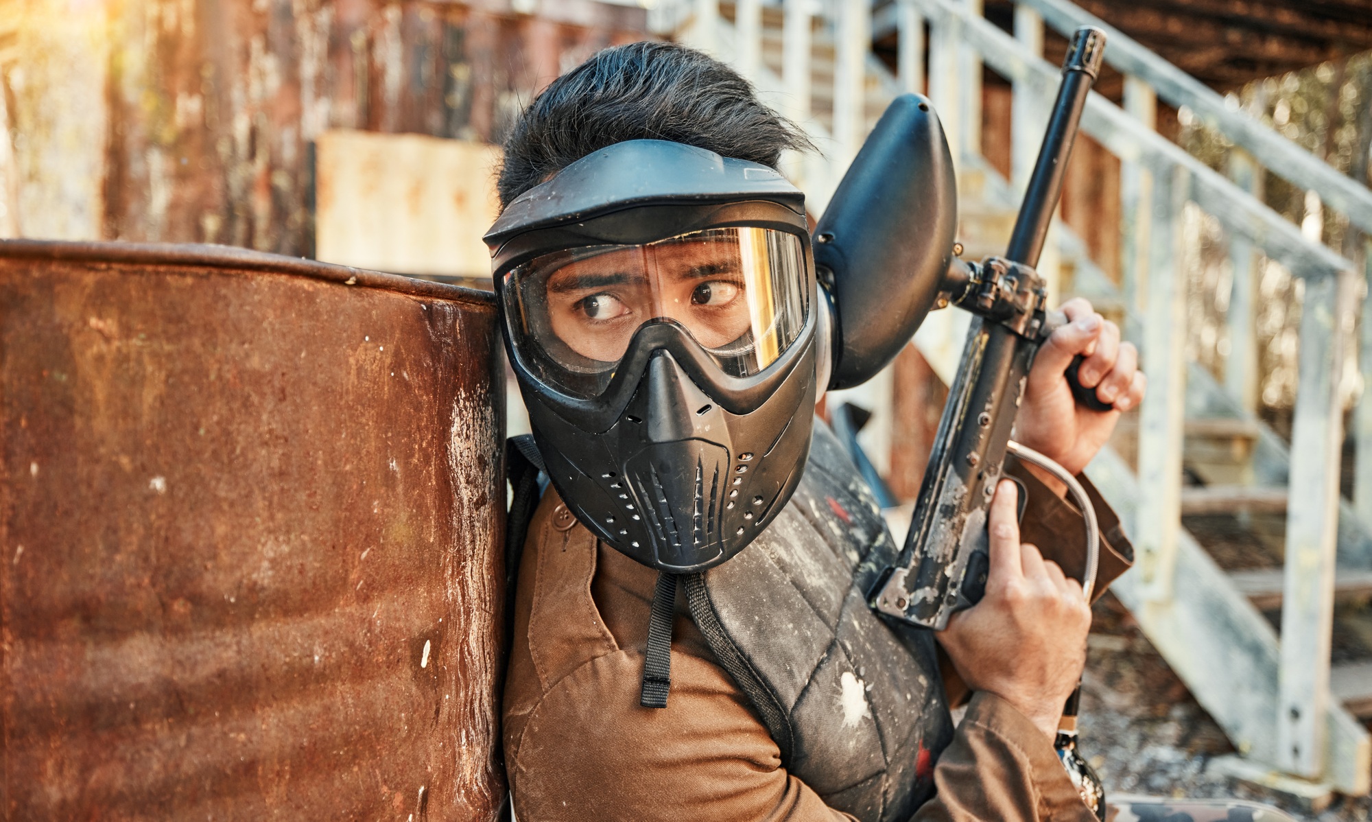 Paintball, adventure and man in action with gun for tournament, competition and battle in nature. E